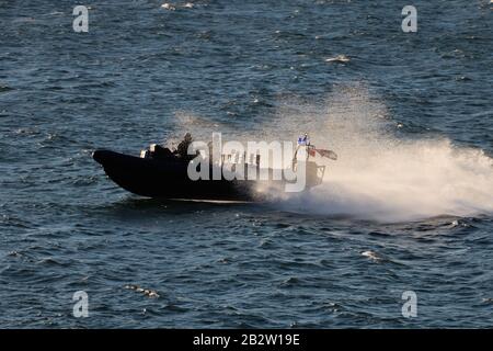 Ein Verteidigungsministerium, RHIB, vor Gourock am Firth of Clyde, fungiert als Eskorte zu einem ankommenden U-Boot der Royal Navy Trafalgar-Klasse. Stockfoto