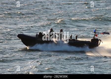 Ein Verteidigungsministerium, RHIB, vor Gourock am Firth of Clyde, fungiert als Eskorte zu einem ankommenden U-Boot der Royal Navy Trafalgar-Klasse. Stockfoto