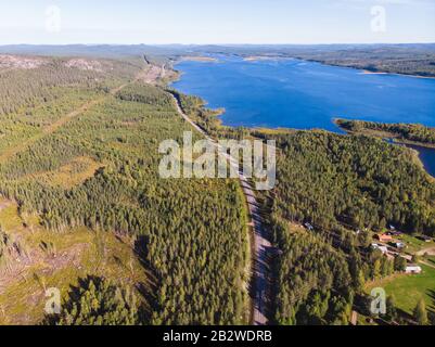 Blick auf den Fluss Kalix, Kalixalven, die Ortschaft Overkalix und den Sitz im schwedischen Kreis Norrbotten, mit Wald im sonnigen Sommertag, Blick auf die Drone Stockfoto