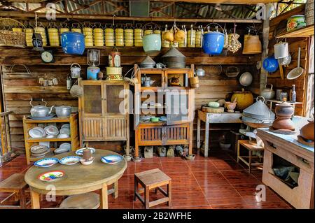 Thailändisches Kücheninnere auf dem Land, das verschiedene Arten von Utensilien und Geräten zeigt und wie sie angeordnet und gelagert werden. Stockfoto