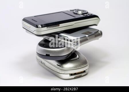 Gestapelte alte Mobiltelefone auf weißem Hintergrund. Stockfoto