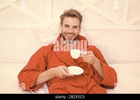 Kaffee am Morgen genießen. Gerne morgen. Schöner Mann trinken Kaffee am Morgen. Happy bärtiger Mann im Bett. Gute Laune. Ab Tag mit guten Kaffee. Entspannt zu Hause. Angenehme Momente. Gourmet Espresso. Stockfoto