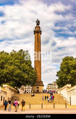 Touristen und Londoner gehen an der Spalte "Herzog von York" vorbei. Andere sitzen auf den Stufen, die zu St James's, London führen. Der Flug der Stufen führt Stockfoto