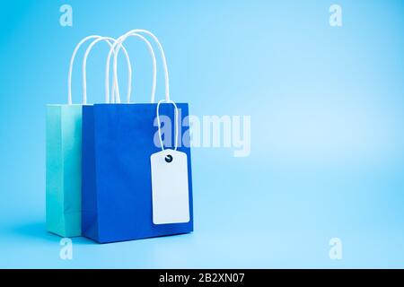Zwei blaue Einkaufs- oder Geschenkbeutel isoliert auf blauem Hintergrund Stockfoto