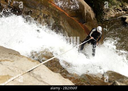 Reifer Mann, Der Einen ecuadorianischen Wasserfall An EINER Richtigen Position Absteigt Stockfoto