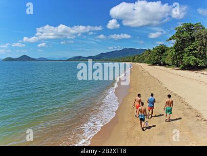 Eine Gruppe asiatischer Besucher machte sich am Morgen auf den Weg zu einem der besten Strände für einen solchen Spaziergang, nämlich Palm Cove Beach, Cairns, QLD AU Stockfoto