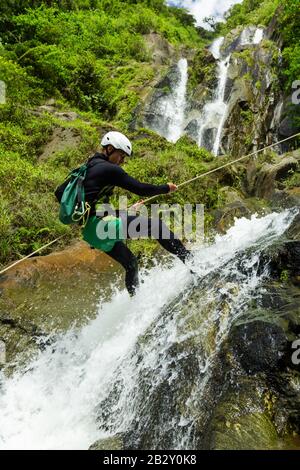 Anführer der Canyoning, Der Einen neuen Kurs In Chama Waterfall Banos De Agua Santa Ecuador Ausprobiert Stockfoto