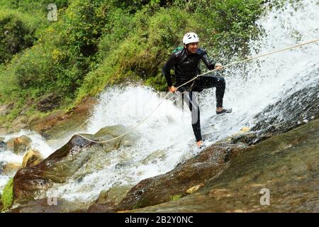 Canyoning Lead Probiert Eine neue Route In Chama Waterfall Banos Ecuador aus Stockfoto