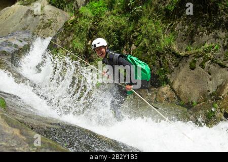 Canyoning Guide Ausprobieren EINES neuen Wegs In Chama Waterfall Banos De Agua Santa Ecuador Stockfoto