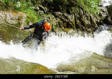 Anführer der Canyoning, Der Eine neue Richtung In Chama Waterfall Banos De Agua Santa Ecuador Ausprobiert Stockfoto