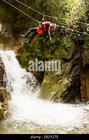 Junge, Dicke Frau, Die Über EINEM Wasserfall Hängt Stockfoto