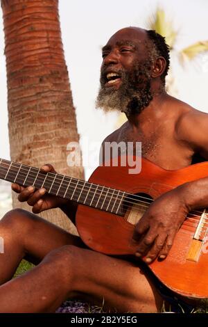 Old Black Men Spielen Gitarre Auf EINER tropischen Insel Stockfoto