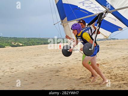 Der Schüler bereitet sich mit einem Lehrer der Kitty Hawk Kites Drachengleitschule auf den Sanddünen auf den Start vor Stockfoto