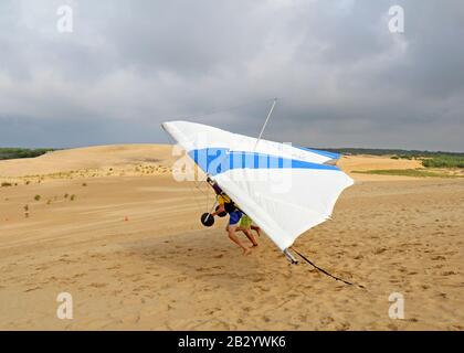 Der Schüler bereitet sich mit einem Lehrer der Kitty Hawk Kites Drachengleitschule auf den Sanddünen auf den Start vor Stockfoto