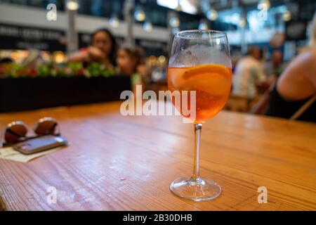 Oranger Spritz-Cocktail aus Weinglas auf Holztisch Stockfoto