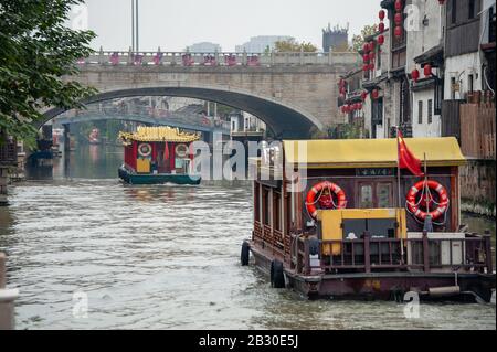 Wuxi China - Oktober 2019: Bunte Lastkähne fahren durch eine traditionelle chinesische Wasserstadt in der antiken Stadt Wuxi, Provinz Jiangsu, China. Stockfoto