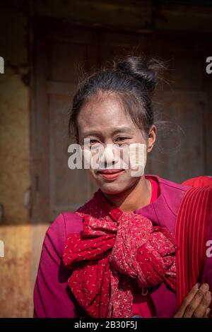 Heho, Myanmar - 31. Januar 2020: Porträt einer birmanischen Frau, die Thanaka trägt, eine gelbe Kosmetikpaste auf ihren Wangen. Wird als Schönheitshilfe verwendet und auch ac Stockfoto