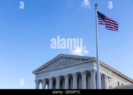 Amerikanische Flagge schwenkt vor dem Obersten Gerichtshof der Vereinigten Staaten aus. Stockfoto