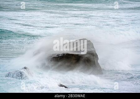 Ein Felsen in einem stürmischen Ozean, Lofoten, Norwegen Stockfoto