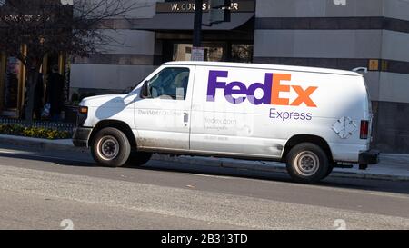 FedEx Express Van dreht an einem sonnigen Tag in D.C. eine Straße in der Innenstadt Stockfoto