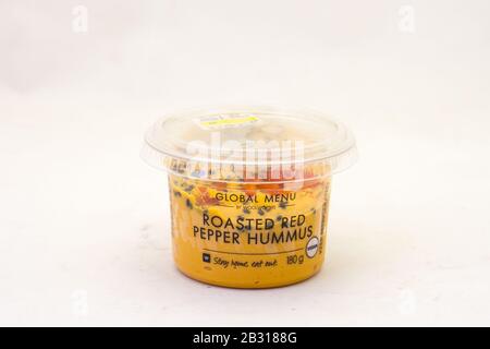 Alberton, Südafrika - eine Wanne roter Pfefferhummus von Woolworths Food, isoliert auf einem klaren Hintergrundbild mit Kopierraum Stockfoto