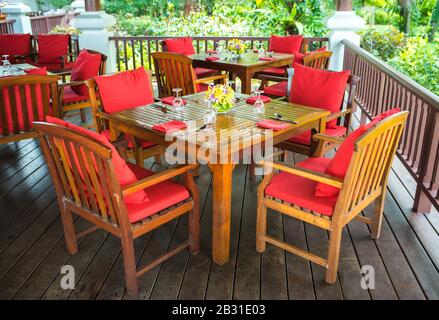 Farbenfrohes, wunderschönes Orchideen-Bouquet-Dekor in Glasvase, eingerichtet auf einem Holz-Esstisch in Indien, Empfang für Hochzeitsfeiern. Stockfoto