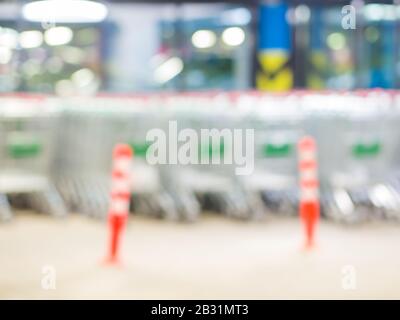 Einkaufswagen in einem Einkaufszentrum-Keller-Parkplatz - Einkaufswagen auf einem Parkplatz. Unscharfes Bild Stockfoto