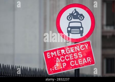 Straßenschild, das den Einstieg von Autos oder Motorrädern verbietet und die Menschen über einen Notzugang informiert, der frei gehalten werden muss. Stockfoto