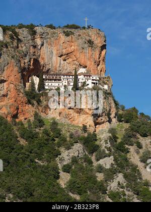 Orthodoxes Kloster, das auf einem schmalen Felsvorsprung errichtet wurde (erhöhter Blick von der anderen Seite des Canyons). Kloster Elonas, Peloponnes, Griechenland. Stockfoto