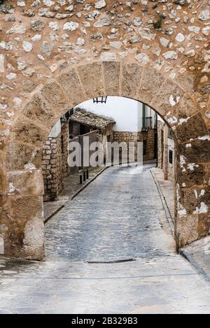 Straße und Steinbogen in der mittelalterlichen Stadt Pastrana in Spanien. Stockfoto