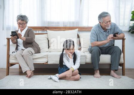 Im Streit sitzen ältere Mutter Erwachsene Tochter getrennt auf der Couch und haben Konflikte, generationenübergreifende Missverständnisse, erwachsenes Enkelkind Oma Diff Stockfoto