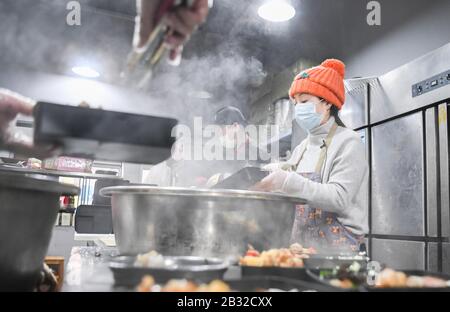 (200304) -- PEKING, 4. März 2020 (Xinhua) -- Frau Liu (R), verpackt Essen mit ihren Teamkollegen in Wuhan, der zentralchinesischen Provinz Hubei, 26. Februar 2020. Liu, ein 24-jähriger Freiwilliger aus der Provinz Sichuan, Fuhr am 3. Februar Dutzende Stunden mit Köchen und Lebensmittelmaterialien aus Chengdu nach Wuhan und hat begonnen, für die medizinischen Arbeiter, die gegen die neuartige Coronavirus-Krankheit (COVID-19) in der von Epidemien heimtauften Stadt kämpfen, zu kochen und kostenlos zu liefern, seit dem 4. Februar. (Xinhua/Cheng Min.) Stockfoto