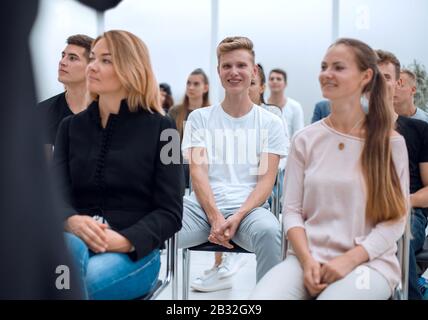 Gruppe verschiedener Jugendlicher, die in einem Konferenzraum sitzen Stockfoto