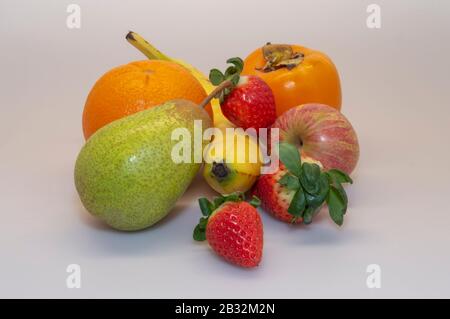 Strawberry, Pear Rock, Banana, Apple, Orange, Persimmon. Abwechslungsreiche Früchte sind essentiell für eine gesunde und ausgewogene Ernährung. Stockfoto