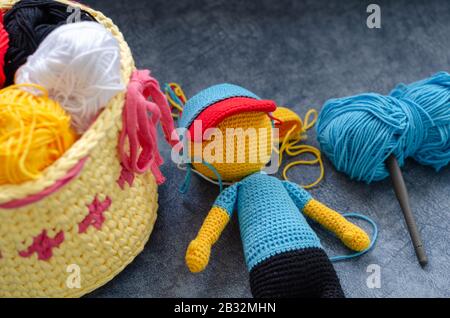 Amigurumi Spielzeug und bunte Fäden auf blauem Hintergrund Stockfoto