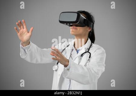 Kaukasische weibliche Ärztin auf grauem Hintergrund Stockfoto
