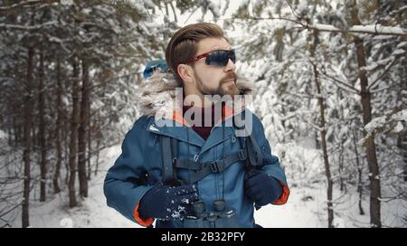 Wanderer, der im schneebedeckten Wald spazieren geht Stockfoto