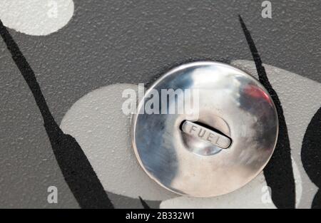 Verchromter Tankdeckel aus Metall mit Aufschrift "Fuel". Der Anstieg der Öl- und Kraftstoffpreise auf dem Weltmarkt. Einsparung bei Diesel mit Elektrofahrzeugen Stockfoto