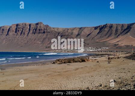 Playa de Famara , ein beliebter Surfstrand, während das nördliche Ende von FKK-Künstlern, Lanzarote, Kanarische Inseln, Spanien, Europa genutzt wird Stockfoto