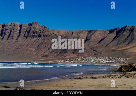 Playa de Famara , ein beliebter Surfstrand, während das nördliche Ende von FKK-Künstlern, Lanzarote, Kanarische Inseln, Spanien, Europa genutzt wird Stockfoto