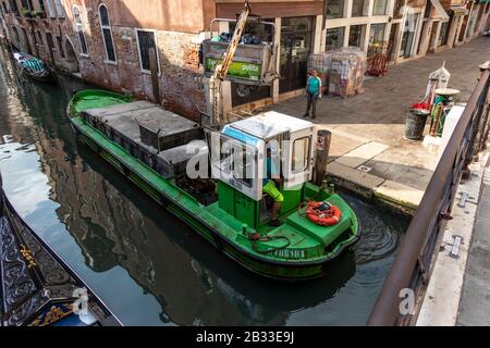 Der Müll-/Abfallsammelkahn von Green stoppte, um täglich Müll zu sammeln. Venedig, Italien Stockfoto