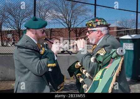 Mitglieder der County Cork Pipes & Drums stimmen ihre Instrumente vor dem Marsch in der Saint Patrick's Day Parade in Sunnyside, Queens, New York, ab. Stockfoto