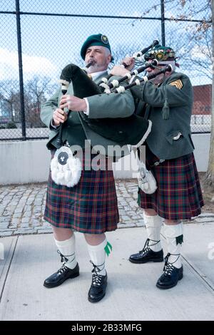 Mitglieder der County Cork Pipes & Drums stimmen ihre Instrumente vor dem Marsch in der Saint Patrick's Day Parade in Sunnyside, Queens, New York, ab. Stockfoto