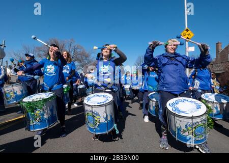 Mitglieder der Fogo Azul All-female Drumline Marching Band wärmen sich vor dem Aufmarsch in der St. Patrick's Day Parade für Alle in Sunnyside, Queens, NYC auf Stockfoto