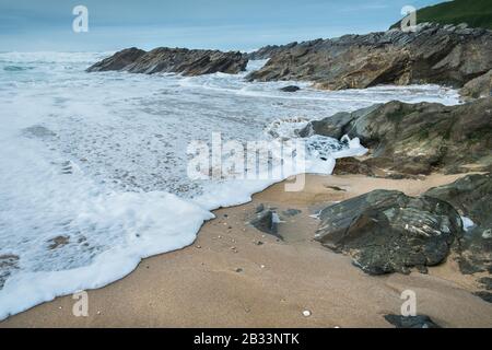 Die Flut, die in Newquay in Cornwall um die Felsen wirbelt, wirbelt. Stockfoto