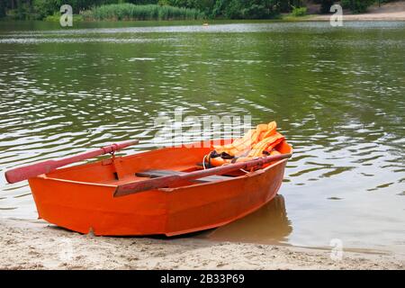 Outfit des Rettungsschwimmers auf dem Wasser im Sommerboot, Rettungsweste, Rettungsschwimmerjacke in orangefarbenem Farbton. Hilfe im Wasser. Stockfoto