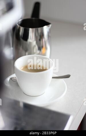 Frisch Gebrühter Kaffee in der Demitasse Tasse von Espresso Machine. Tasse Kaffee an der Theke. Kaffeepause. Stockfoto