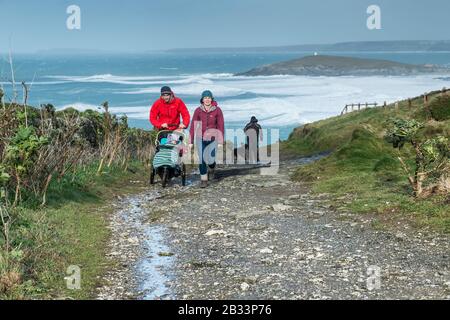 Eine junge Familie, die auf dem South West Coast Path in South Fistral in Newquay in Cornwall spazieren geht. Stockfoto