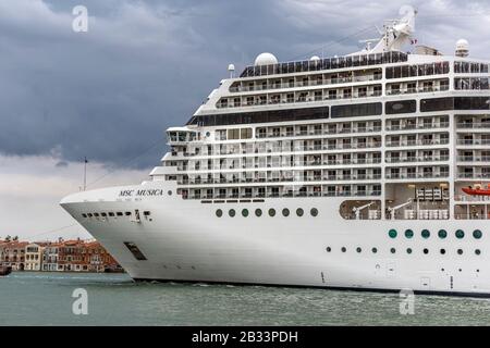 Das riesige Kreuzfahrtschiff MSC Musica dominiert am Abend die Skyline von Venedig, italien. Stockfoto