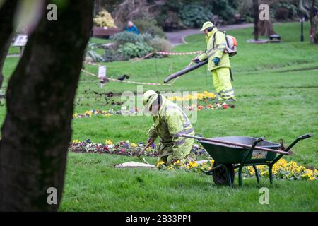 Gartenpflegearbeiter, die Hi-Vis-Kleidung tragen, arbeiten in den Trenance Gardens in Newquay in Cornwall. Stockfoto